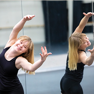 Female student dances in front of a mirror