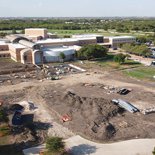 An empty lot that has signs of construction and will house the new Student Experience Building.